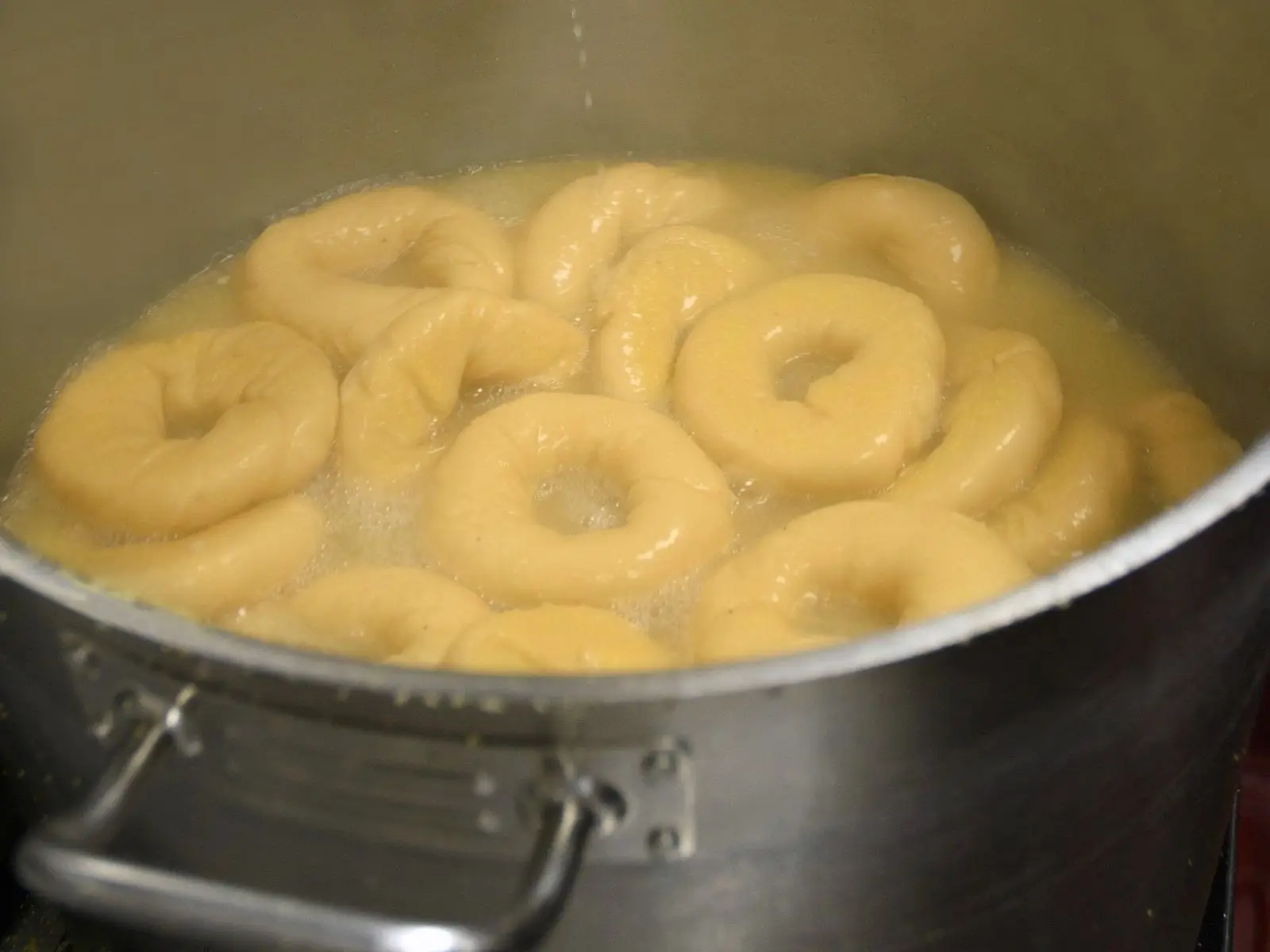 Bagels boiling in a big steel kettle