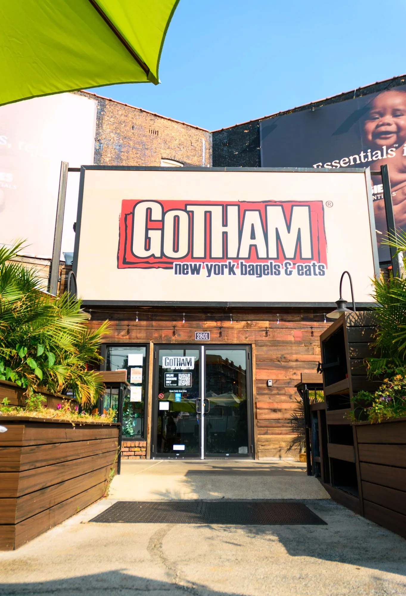 The front door of Gotham Bagels Lakeview at 2801 N Lincoln Ave, under the Gotham sign, with planters on either side