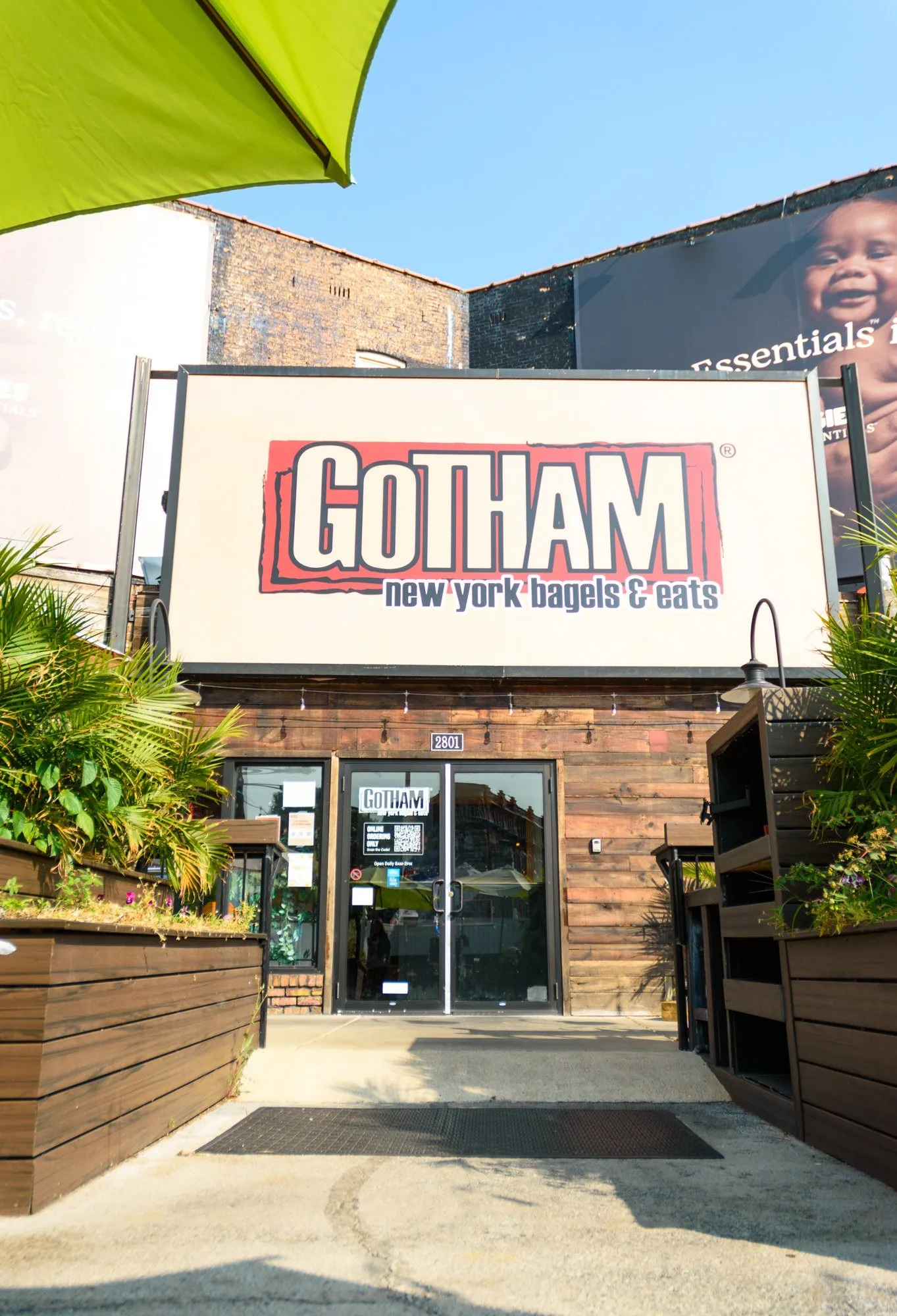 The front door of Gotham Bagels Lakeview at 2801 N Lincoln Ave, under the Gotham sign, with planters on either side