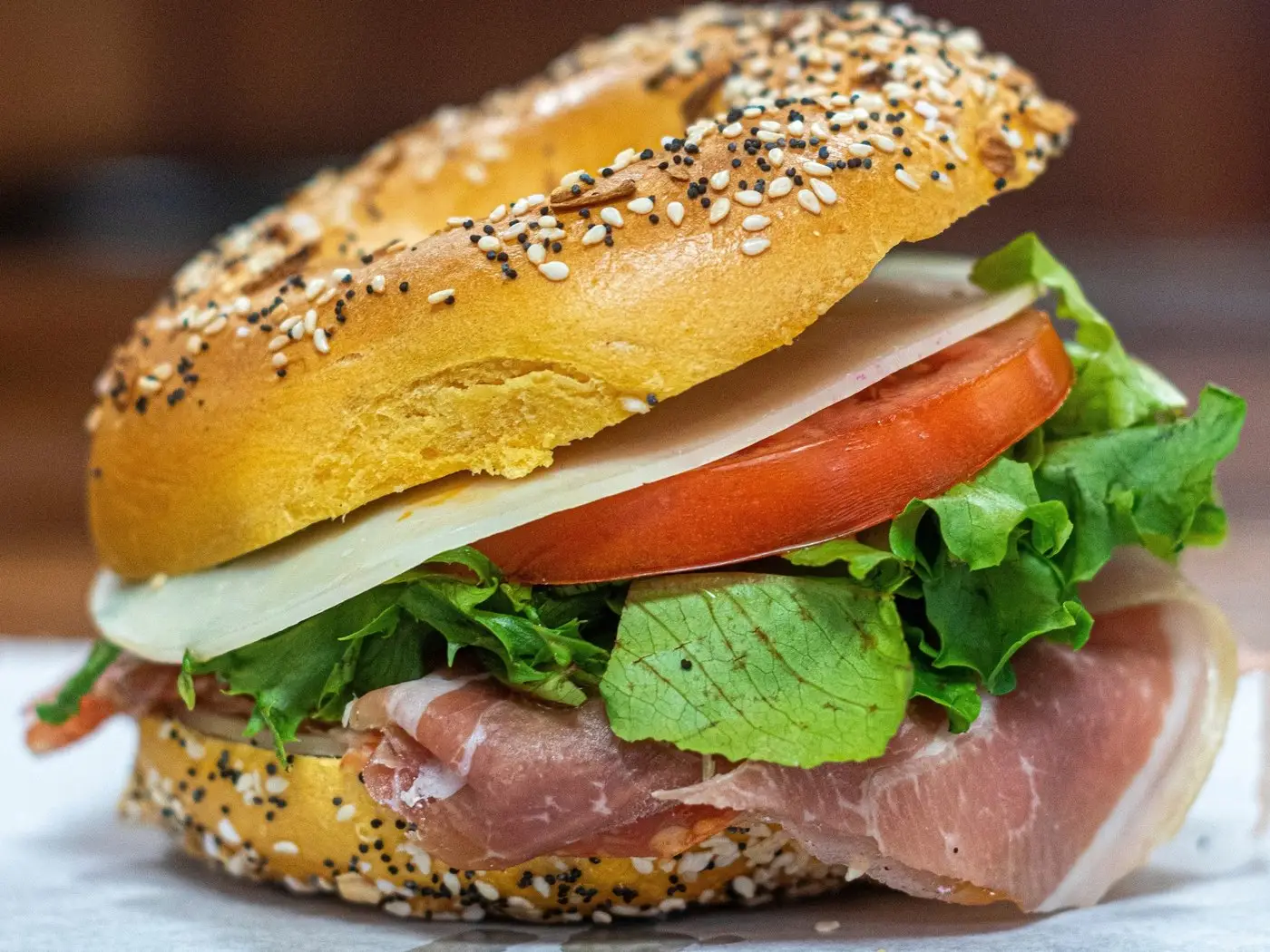 The Bronx Bomber at Gotham Madison: prosciutto, provolone, tomato and greens piled high on an everything bagel